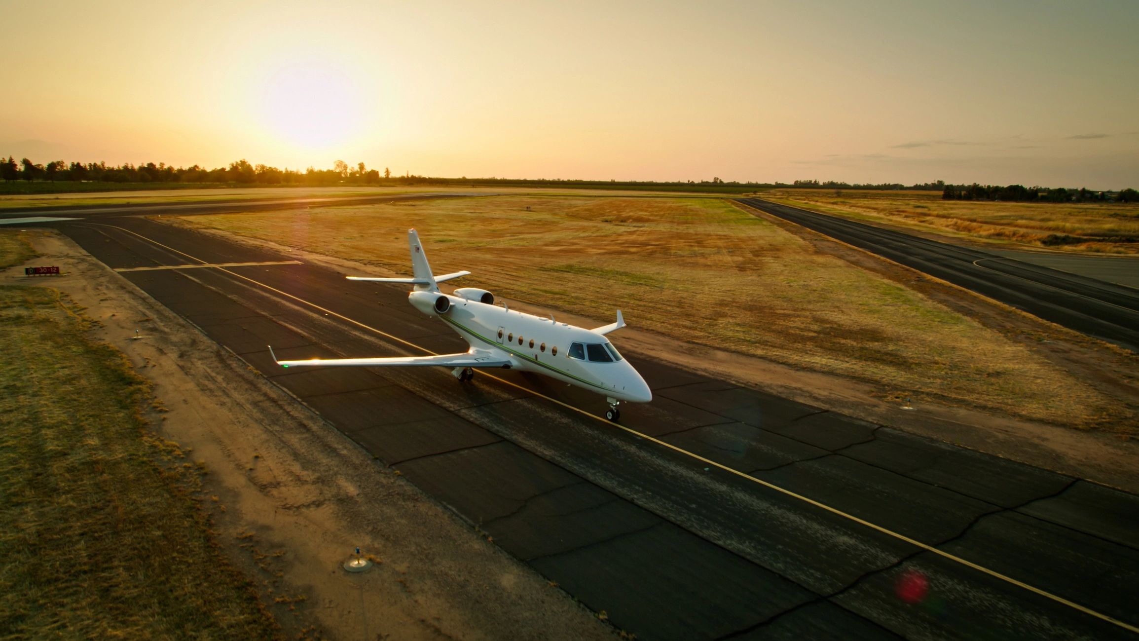 Private jet on runway at sunset